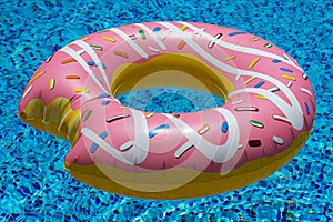 Pink inflatable donut doughnut floating mattress in swimming pool. Beach pool accessories. Summer holiday concept