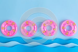 Pink inflatable pool floats and waves made of paper abstract