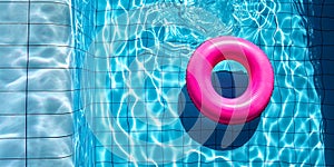 A pink inflatable ring is floating in a pool. Summer resort and water safety concept