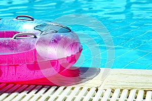 Pink inflatable round tube in swimming pool