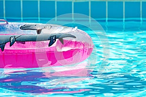 Pink inflatable round tube in swimming pool