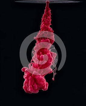Pink ink in water on a black background. Color blast