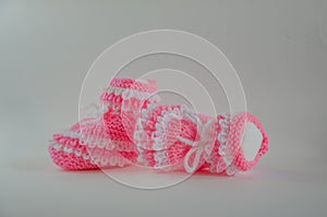 Pink knitted baby booties socks on white background