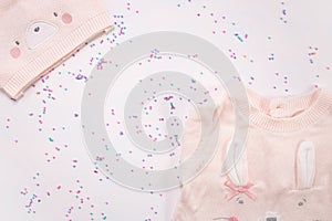 Pink knitted cap and romper on white background. Copy space. Baby born concept.