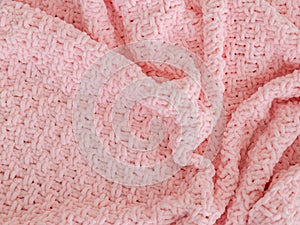 Pink knitted plaid close-up. Background. Creases on soft surfaces