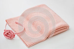 Pink knitted plaid lies on a white surface