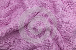 Pink knitted wool texture. Wool knit fabric. Knitted background. Crinkled wool knit texture. Pink knitted background.