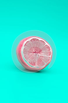 Pink lemon on a green background, the concept of changing yourself and your nature