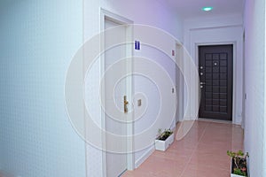 Pink light .Door way space interior lighting design . White walls and door in corridor with wooden floor . Square photo