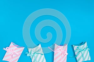 pink and light green gift boxes placed on a blue background located bottom of the picture