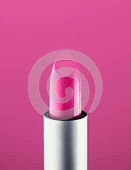 Pink Lipstick close-up, over pink background. Purple color lip stick, closeup. Lip gloss, make-up concept