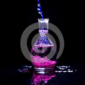 a pink liquid is being poured into a glass bottle