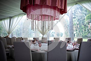 Pink luxury table flower decoration with glass globets indoor wedding event party, coctel table with candles photo