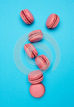Pink macarons on blue background, top view