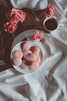 Pink macaroons with coffee cup and pink rose in vintage tone.
