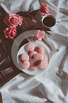 Pink macaroons with coffee cup and pink rose in vintage tone.