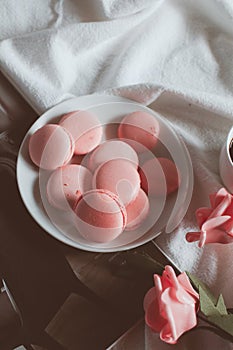 Pink macaroons with coffee cup and pink rose in vintage tone.