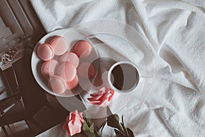 Pink macaroons with coffee cup and pink rose in vintage tone.