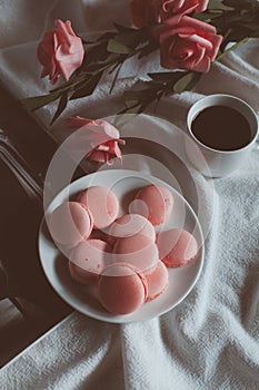 Pink macaroons with coffee cup and pink rose in vintage tone.