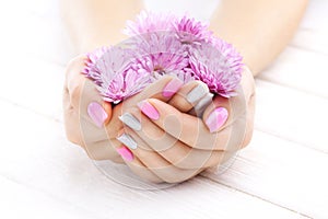 Pink manicure with chrysanthemum flowers. spa