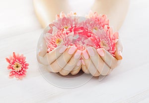 Pink manicure with chrysanthemum flowers. spa