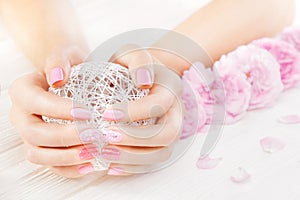 Pink manicure with fresh tea rose, white ball of yarn