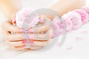 Pink manicure with fresh tea rose, white ball of yarn