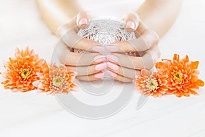 Pink manicure with orange chrysanthemum flowers. spa