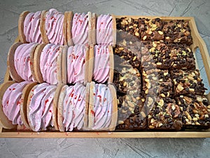 Pink marshmallows and brownies in a wooden box. On a gray background
