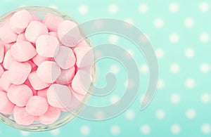 Pink marshmallows on polkadot blue blurred background