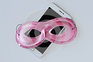 Pink mask on mobile phone - Concept of privacy, security and anonymity of mobile phone for women photo