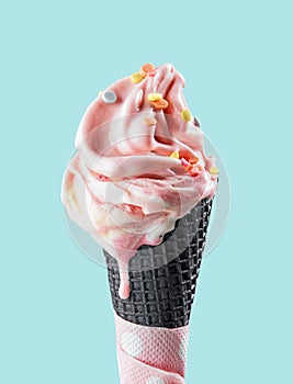 Pink melting ice cream in black waffle cone photo