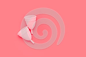 Pink menstrual cup on color background, female intimate hygiene period products, top view