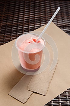 Pink milkshake with juice in a transparent glass. vertical view