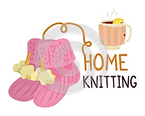 Pink mittens yarn knitting needles beside warm mug lemon. Cozy crafts hot drink concept