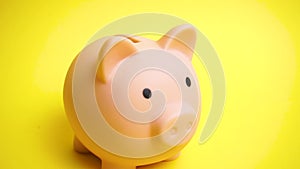 Pink money box bank at yellow background