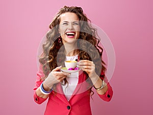 Cheerful young woman with cup of coffee and chocolate candies