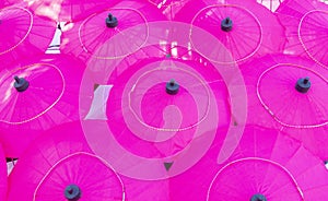 Pink mulberry paper umbrellas placed together in a group