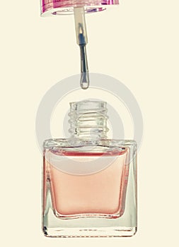 Pink nail polish bottle with brush, closeup