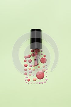 Pink nail polish bottle silhouette made from nail polish drops and splashes isolated on green background