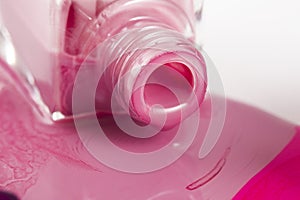 Pink nail polish bottle with splatters isolated