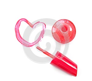 Pink nail polish and brush draw heart shape on white background