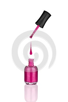 Pink nail polish glass bottle, brush & drop on white background isolated closeup with mirror reflection, opened varnish package