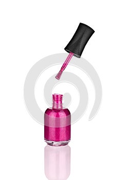 Pink nail polish glass bottle, brush & mirror reflection white background isolated closeup, open varnish package & shadow, lacquer