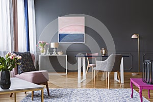 Pink and navy blue painting in grey living room interior with fl