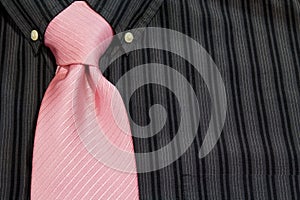 Pink necktie tied on black pinstriped shirt