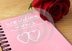 Pink notepad with wedding vows and rose.