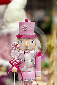 Pink nutcracker man, wooden Christmas toy on  store shelf.