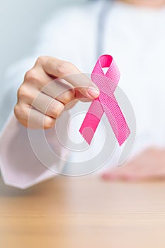 Pink October Breast Cancer Awareness month, woman doctor with pink Ribbon in hospital for support people life and illness.