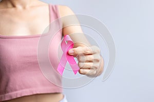 Pink October Breast Cancer Awareness month, woman hand hold pink Ribbon and wear shirt for support people life and illness.